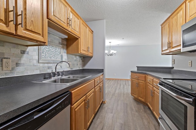 10787 Unity Ln N, Brooklyn Park, MN 55443 - kitchen featuring stainless steel appliances, dark countertops, dark wood-type flooring, tasteful backsplash, and a chandelier