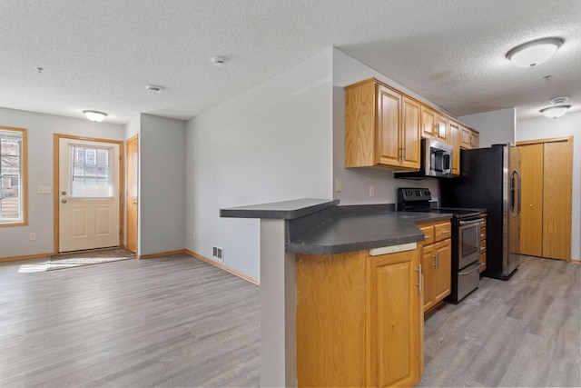 10787 Unity Ln N, Brooklyn Park, MN 55443 - kitchen with appliances with stainless steel finishes, dark countertops, light wood-style flooring, and a textured ceiling