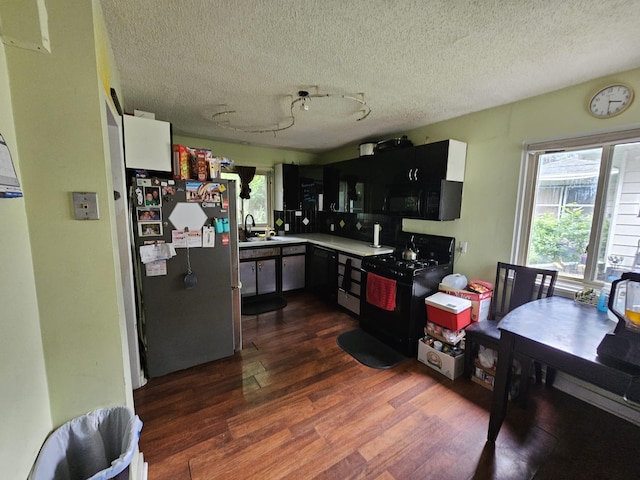 216 Hobart St, Owatonna, MN 55060 - kitchen with black appliances, dark wood-style flooring, plenty of natural light, a textured ceiling, and light countertops