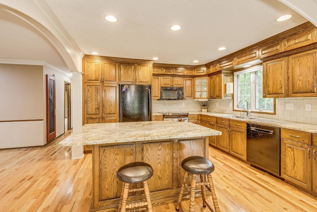 989 Kadler Ave NE, Saint Michael, MN 55376 - kitchen featuring black appliances, brown cabinets, crown molding, light wood finished floors, and recessed lighting