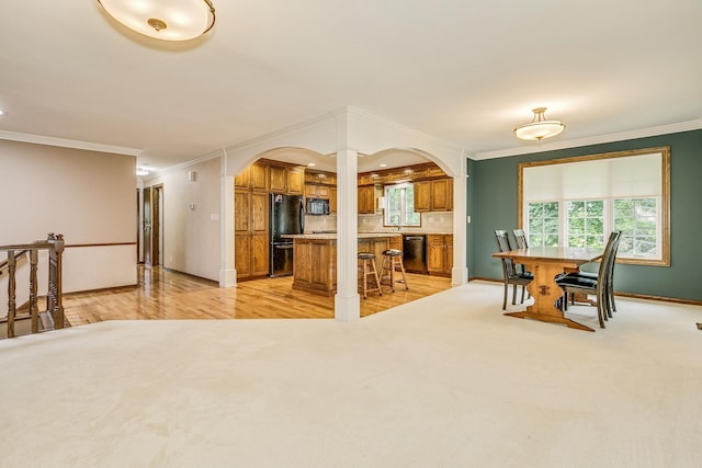 989 Kadler Ave NE, Saint Michael, MN 55376 - kitchen with brown cabinetry, black appliances, arched walkways, decorative columns, and crown molding