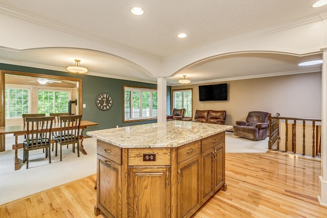 989 Kadler Ave NE, Saint Michael, MN 55376 - kitchen featuring light wood finished floors, brown cabinetry, plenty of natural light, light stone countertops, and crown molding
