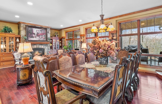 12322 Coffee Trl, Rosemount, MN 55068 - dining area with crown molding, a chandelier, dark wood finished floors, a fireplace, and recessed lighting
