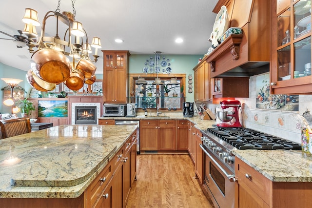 12322 Coffee Trl, Rosemount, MN 55068 - kitchen featuring appliances with stainless steel finishes, light wood-type flooring, decorative backsplash, light stone counters, and brown cabinetry