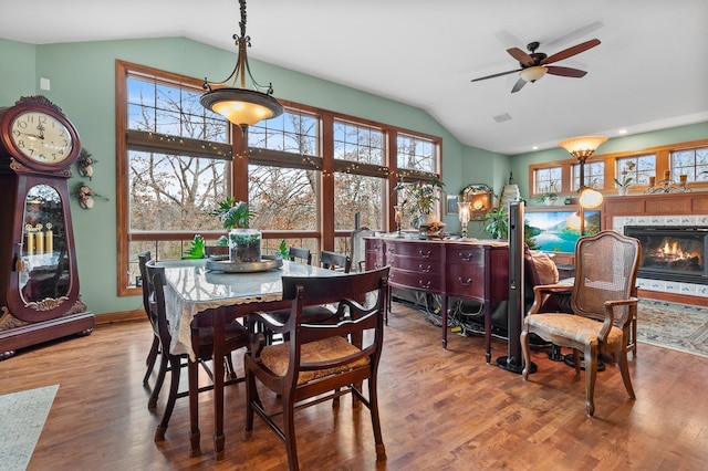 12322 Coffee Trl, Rosemount, MN 55068 - dining area featuring lofted ceiling, a ceiling fan, wood finished floors, and a lit fireplace