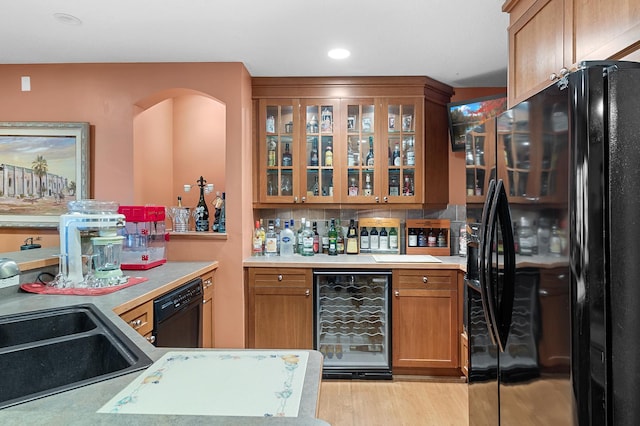 12322 Coffee Trl, Rosemount, MN 55068 - kitchen featuring black appliances, wine cooler, brown cabinetry, glass insert cabinets, and light wood-style flooring