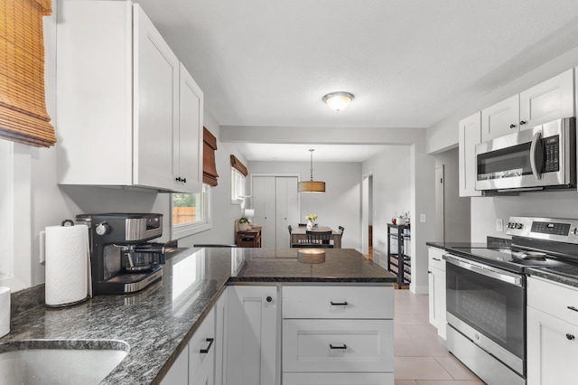 4633 Ewing Ave N, Robbinsdale, MN 55422 - kitchen featuring appliances with stainless steel finishes, a peninsula, white cabinetry, and light tile patterned floors
