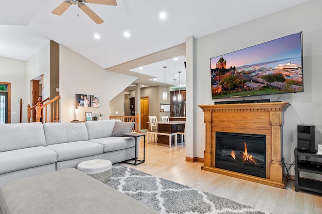 4326 Donway Dr NE, Alexandria, MN 56308 - living room with wood finished floors, a ceiling fan, lofted ceiling, a glass covered fireplace, and recessed lighting