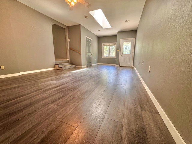 300 Lyon St, Minneota, MN 56264 - spare room featuring wood finished floors, a skylight, stairway, and a textured wall
