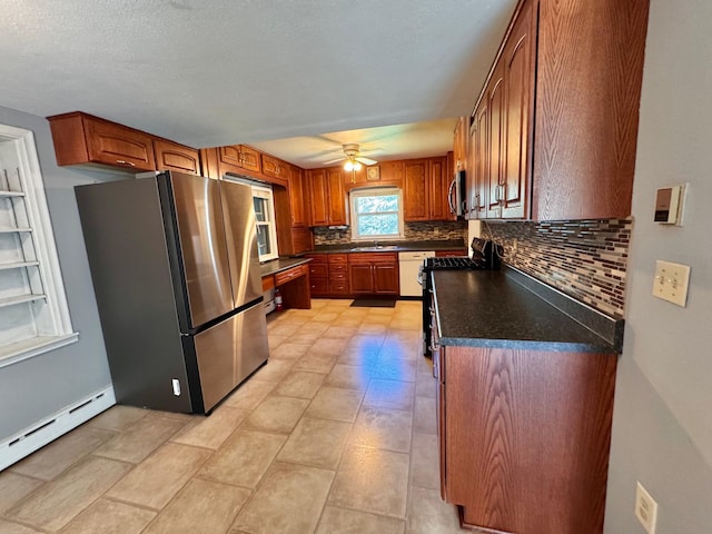 300 Lyon St, Minneota, MN 56264 - kitchen with appliances with stainless steel finishes, tasteful backsplash, dark countertops, a ceiling fan, and a baseboard radiator