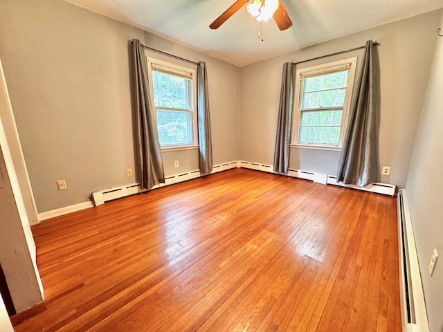 300 Lyon St, Minneota, MN 56264 - spare room featuring a baseboard radiator, plenty of natural light, wood-type flooring, and a ceiling fan