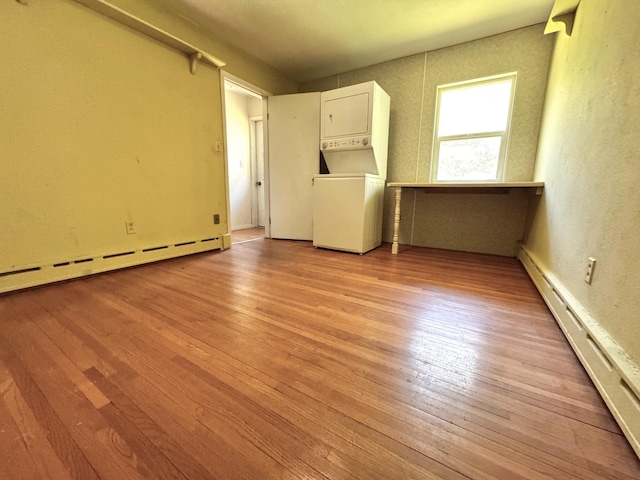 300 Lyon St, Minneota, MN 56264 - spare room with stacked washer / dryer, baseboard heating, light wood finished floors, a baseboard heating unit, and a textured wall