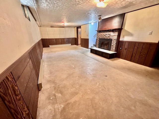 300 Lyon St, Minneota, MN 56264 - unfurnished living room with wainscoting, a fireplace, wood walls, a baseboard heating unit, and concrete flooring
