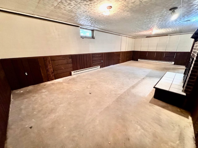 300 Lyon St, Minneota, MN 56264 - below grade area featuring baseboard heating, wooden walls, and wainscoting