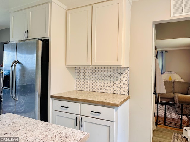 10701 6th St NE, Blaine, MN 55434 - kitchen featuring stainless steel fridge, light countertops, tasteful backsplash, wood finished floors, and white cabinets