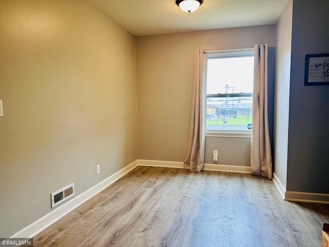 10701 6th St NE, Blaine, MN 55434 - spare room with wood finished floors and a textured ceiling