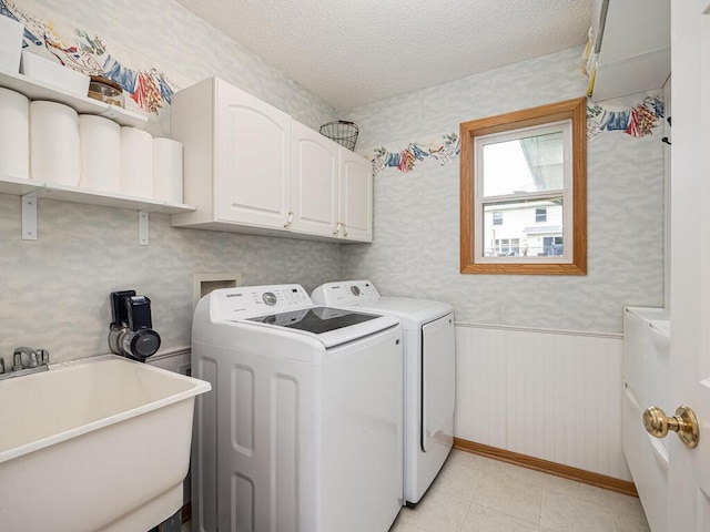18232 Roosevelt St NW, Elk River, MN 55330 - laundry area featuring washer and dryer, a wainscoted wall, a textured ceiling, cabinet space, and wallpapered walls