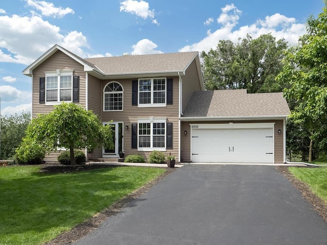 18232 Roosevelt St NW, Elk River, MN 55330 - colonial house featuring a garage, driveway, a front lawn, and a shingled roof