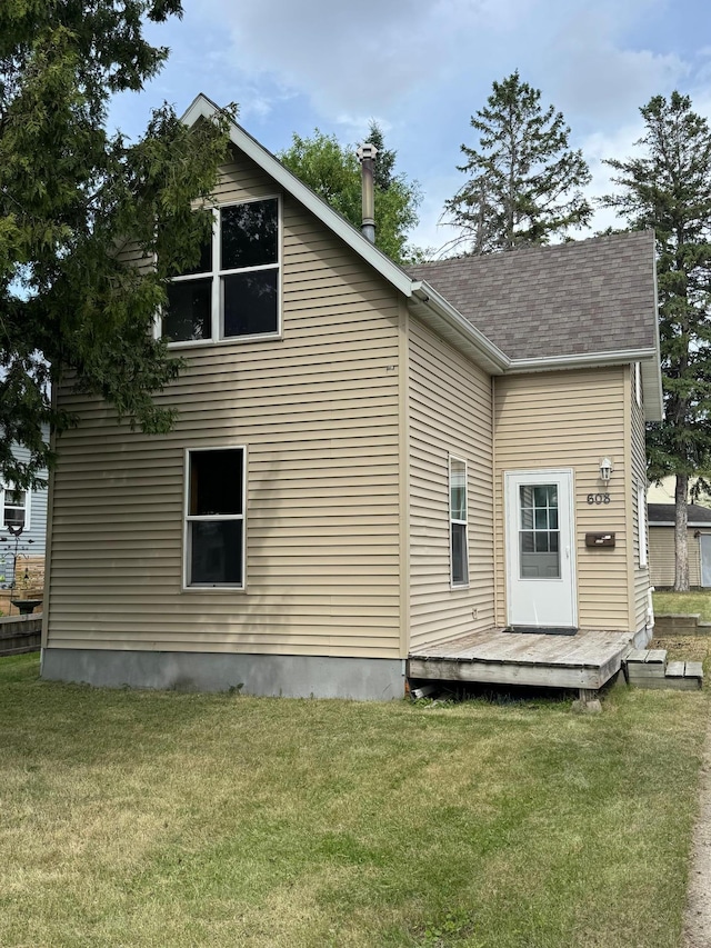 608 Duluth Ave N, Thief River Falls, MN 56701 - back of property with a wooden deck, a lawn, and a shingled roof