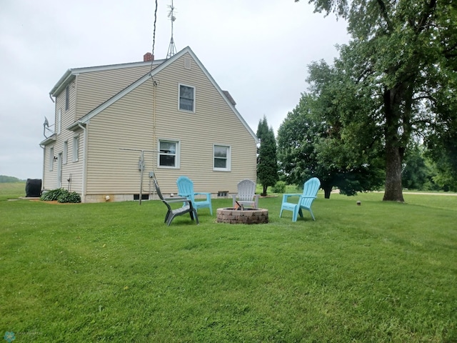 72558 209th St, Collinwood Twp, MN 55325 - back of house with a lawn, a chimney, and an outdoor fire pit