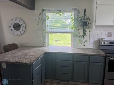 72558 209th St, Collinwood Twp, MN 55325 - kitchen with stainless steel electric stove, backsplash, a peninsula, and wood finished floors