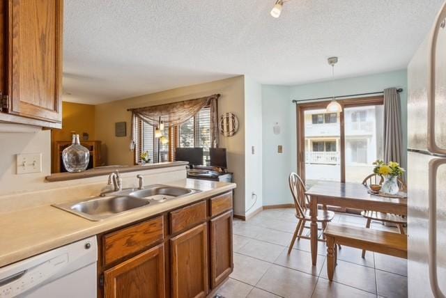 3335 Nevada Ave N Unit 3502, Crystal, MN 55427 - kitchen featuring white dishwasher, a textured ceiling, brown cabinets, hanging light fixtures, and light countertops