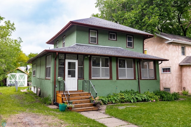 1205 11th St S, Fargo, ND 58103 - american foursquare style home with stucco siding, a front yard, a shed, and roof with shingles