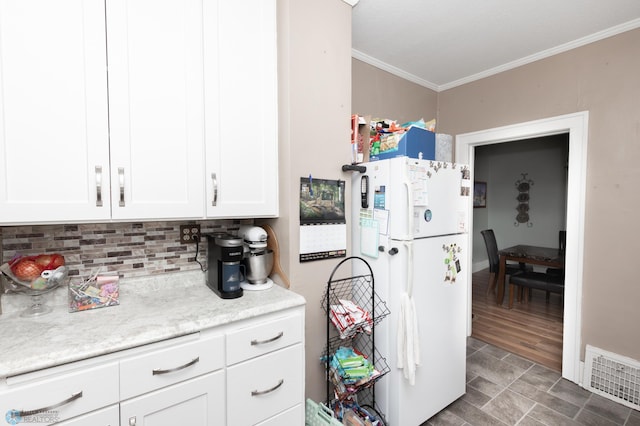 1205 11th St S, Fargo, ND 58103 - kitchen with freestanding refrigerator, crown molding, light countertops, white cabinets, and tasteful backsplash