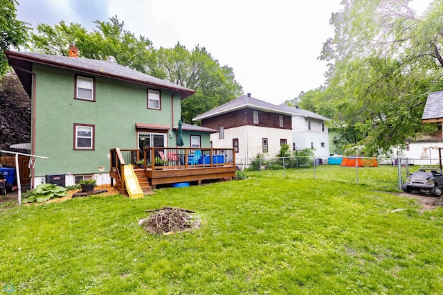 1205 11th St S, Fargo, ND 58103 - rear view of house with a deck, a fenced backyard, a chimney, and stucco siding