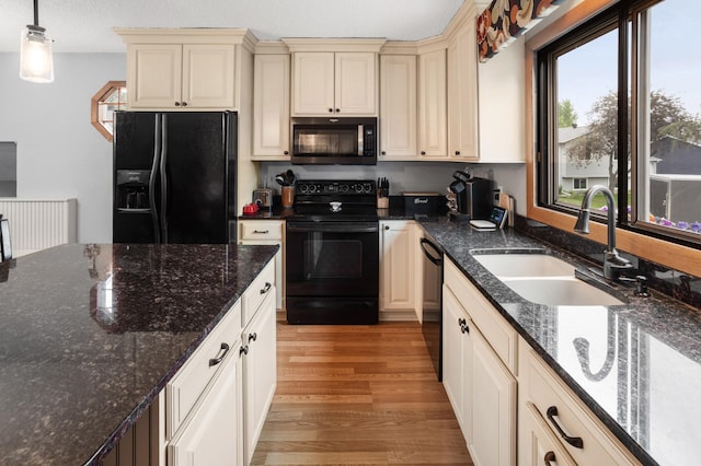 2900 16th Ave S, Moorhead, MN 56560 - kitchen featuring black appliances, cream cabinetry, light wood-style flooring, and pendant lighting