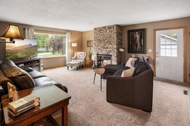 2900 16th Ave S, Moorhead, MN 56560 - living room featuring carpet, healthy amount of natural light, a textured ceiling, and a stone fireplace