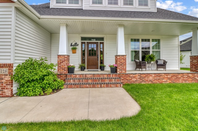 6728 Ashwood Loop, Fargo, ND 58104 - property entrance with a shingled roof, a porch, and a yard