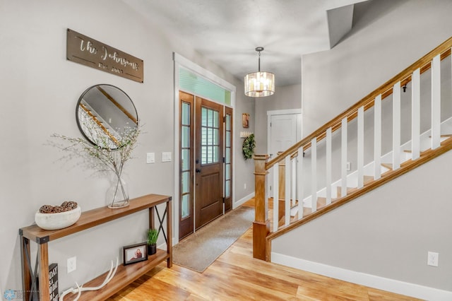6728 Ashwood Loop, Fargo, ND 58104 - entryway with wood finished floors, stairway, and a chandelier