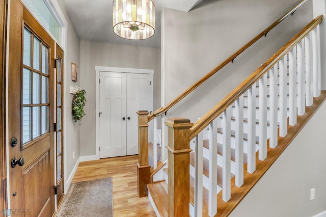 6728 Ashwood Loop, Fargo, ND 58104 - entryway with light wood-type flooring, stairs, and a chandelier