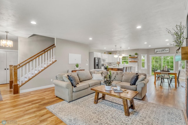 6728 Ashwood Loop, Fargo, ND 58104 - living area featuring a chandelier, light wood-style floors, stairs, and recessed lighting