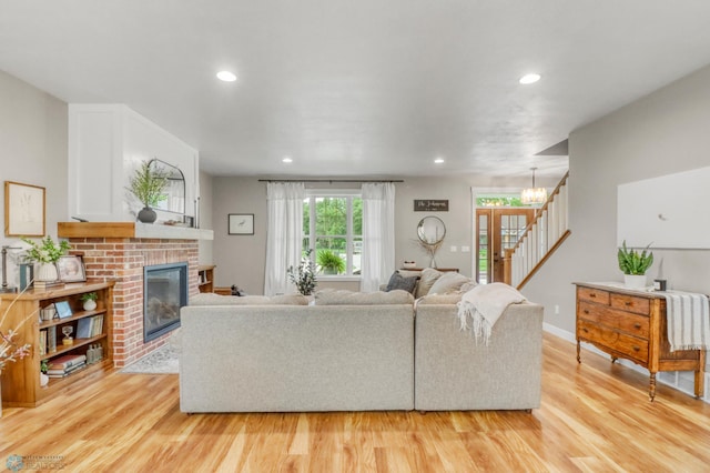 6728 Ashwood Loop, Fargo, ND 58104 - living room featuring light wood-style floors, stairs, a brick fireplace, and recessed lighting