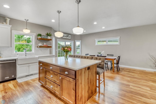 6728 Ashwood Loop, Fargo, ND 58104 - kitchen featuring stainless steel dishwasher, a kitchen breakfast bar, light wood finished floors, recessed lighting, and light countertops