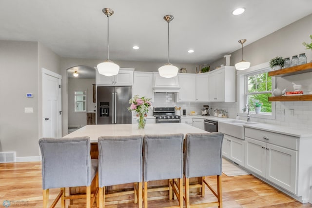 6728 Ashwood Loop, Fargo, ND 58104 - kitchen with stainless steel appliances, a kitchen island, decorative backsplash, white cabinets, and recessed lighting
