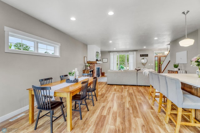 6728 Ashwood Loop, Fargo, ND 58104 - dining room featuring light wood-style floors, recessed lighting, stairs, and a fireplace