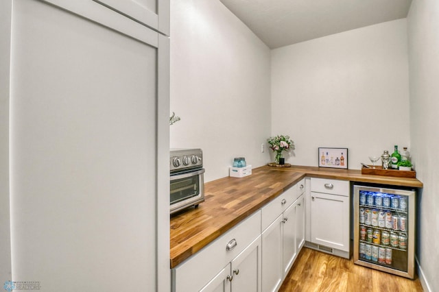 6728 Ashwood Loop, Fargo, ND 58104 - indoor dry bar with refrigerator, wine cooler, and light wood-type flooring