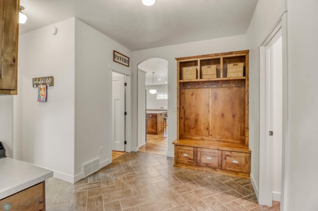 6728 Ashwood Loop, Fargo, ND 58104 - mudroom featuring arched walkways and baseboards