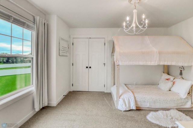 6728 Ashwood Loop, Fargo, ND 58104 - bedroom with light carpet, a chandelier, and a closet