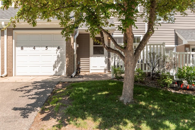 8454 Copperfield Way Unit 75, Inver Grove Heights, MN 55076 - view of front facade with brick siding, asphalt driveway, a front lawn, an attached garage, and roof with shingles