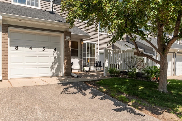 8454 Copperfield Way Unit 75, Inver Grove Heights, MN 55076 - doorway to property featuring roof with shingles, asphalt driveway, and brick siding