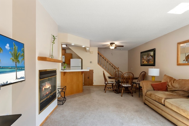 8454 Copperfield Way Unit 75, Inver Grove Heights, MN 55076 - living room featuring light colored carpet, a glass covered fireplace, ceiling fan, and stairs