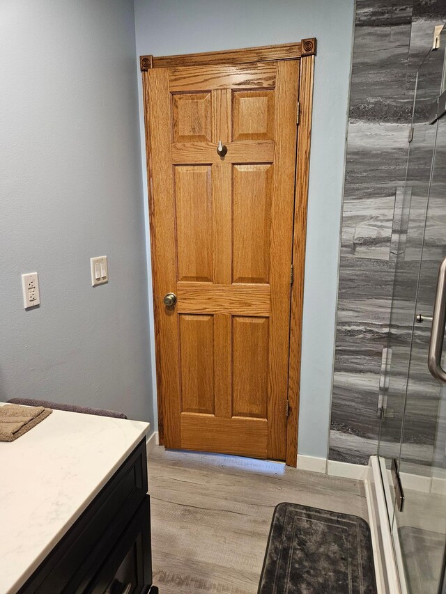 611 3rd St SW, Richville, MN 56576 - bathroom with wood finished floors, vanity, and a shower stall