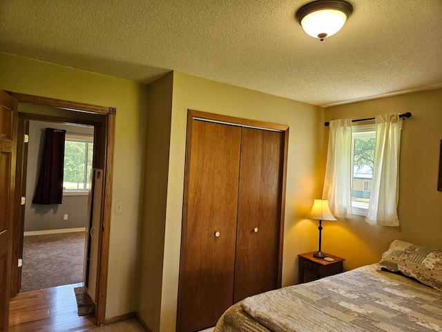 611 3rd St SW, Richville, MN 56576 - bedroom featuring a closet, a textured ceiling, and wood finished floors