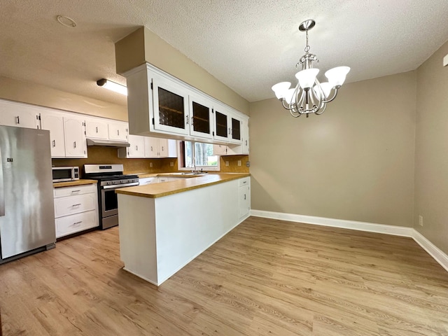 2360 3rd St NW, New Brighton, MN 55112 - kitchen featuring appliances with stainless steel finishes, a chandelier, a peninsula, a textured ceiling, and white cabinets