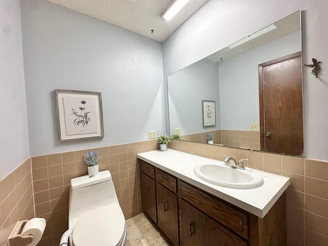 2360 3rd St NW, New Brighton, MN 55112 - bathroom featuring tile walls, vanity, wainscoting, and a textured ceiling