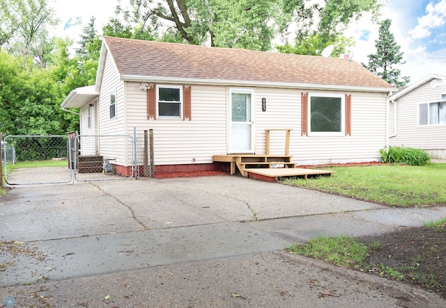 405 18th St N, Moorhead, MN 56560 - view of front of house with a gate, a shingled roof, and driveway